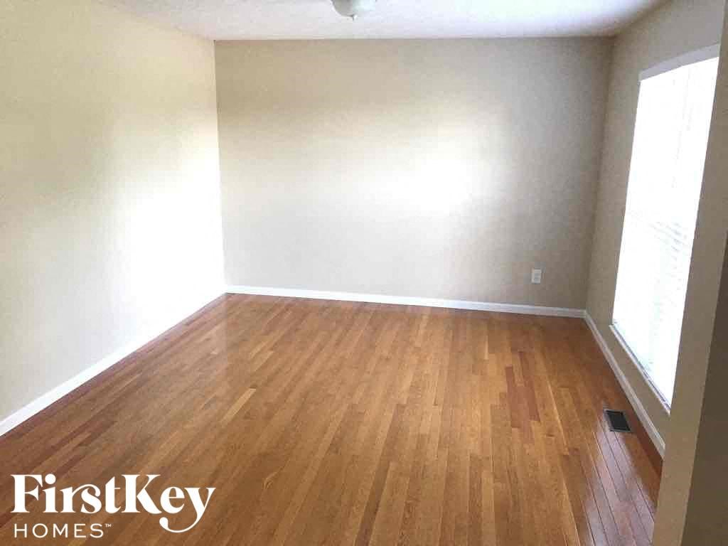 an empty room with wood flooring in an empty house