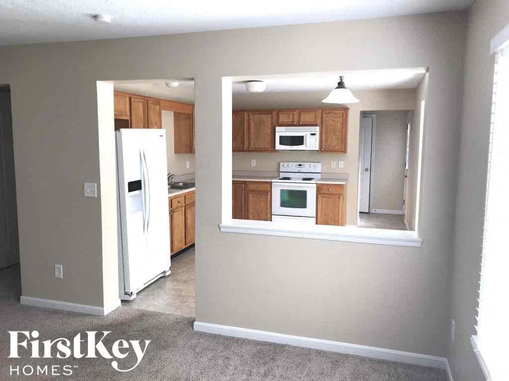 a small kitchen with wooden cabinets and a white refrigerator