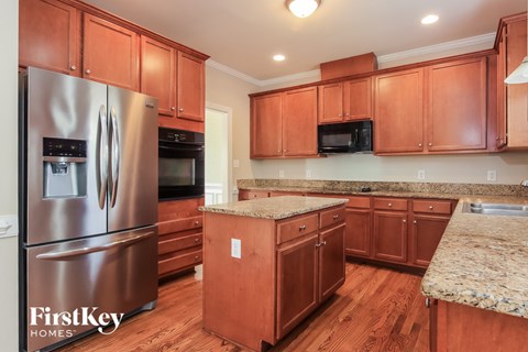 A kitchen with wooden cabinets and a granite counter top.