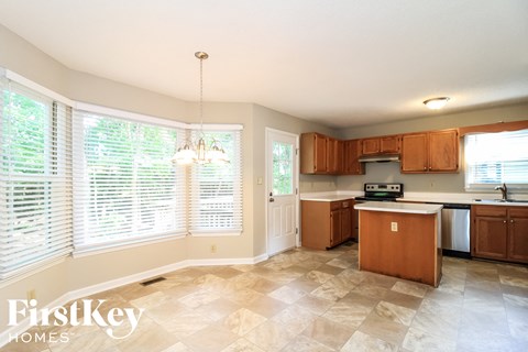 A kitchen with wooden cabinets and a tiled floor.