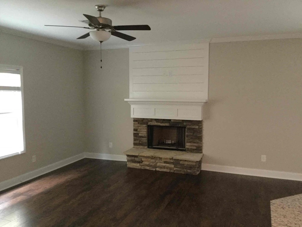 A room with a fireplace and a ceiling fan.