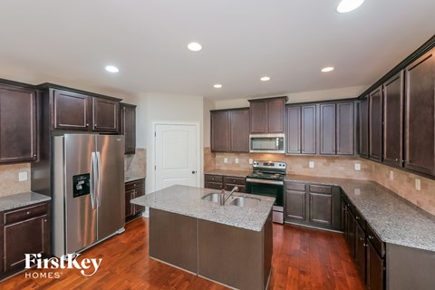 a large kitchen with stainless steel appliances and granite counter tops