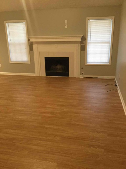 a living room with a hard wood floor and a fireplace