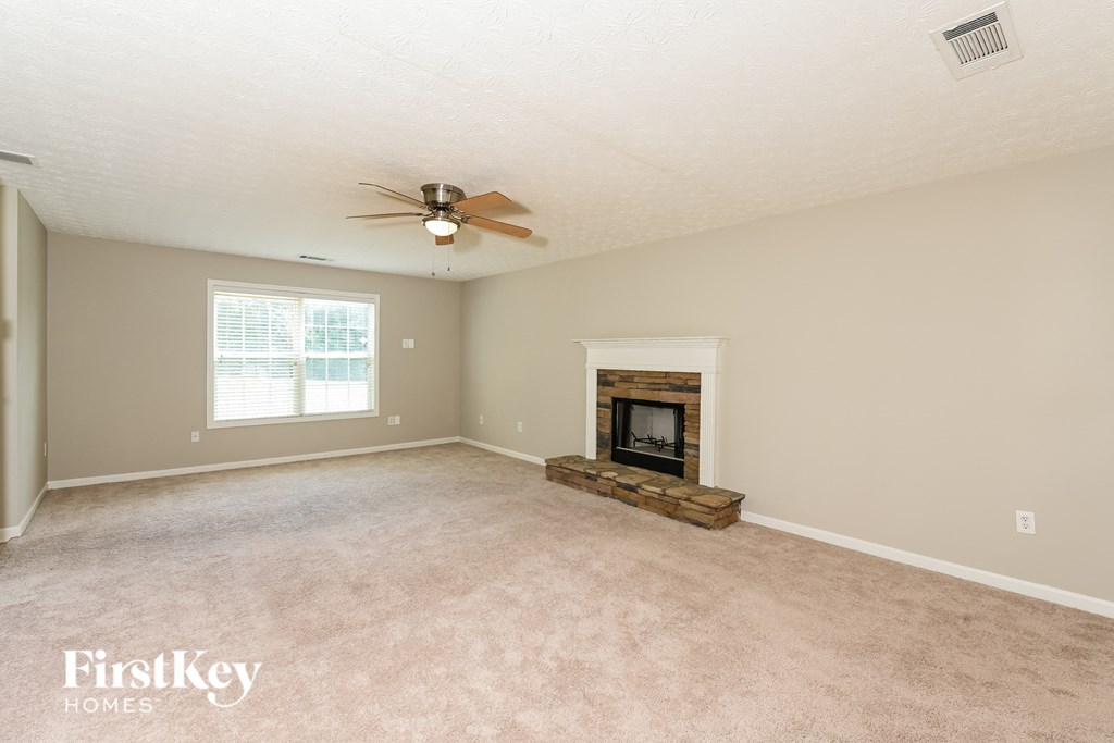 a living room with a fireplace and a ceiling fan