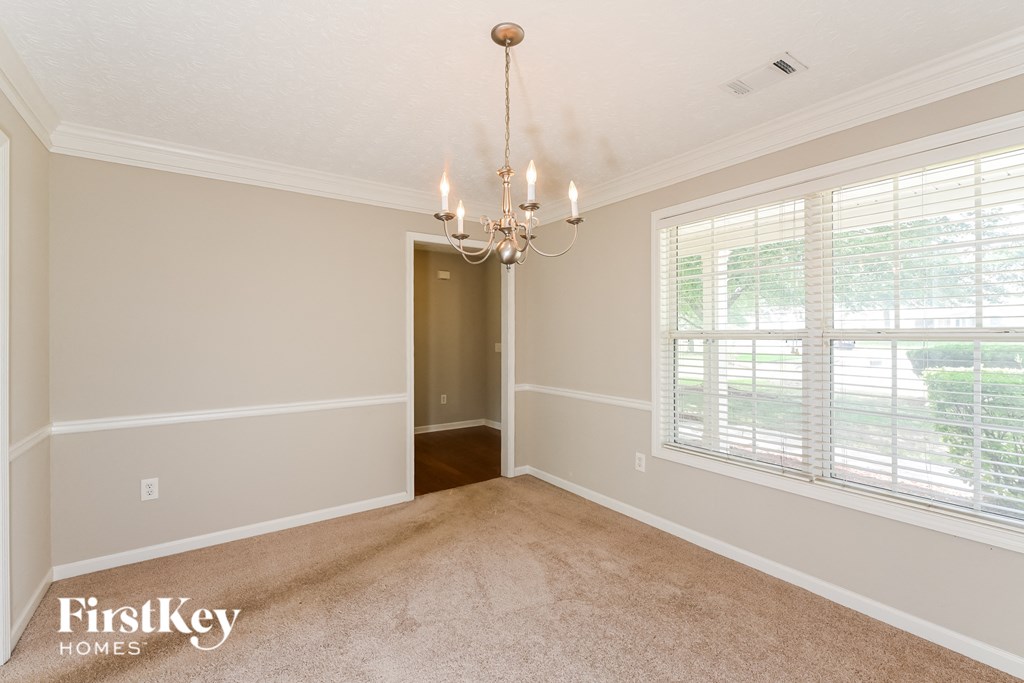a dining room with a chandelier and a large window