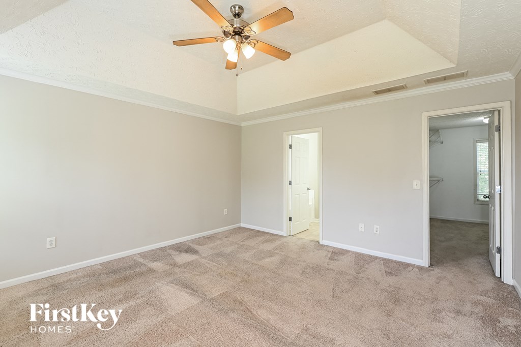 a living room with carpet and a ceiling fan