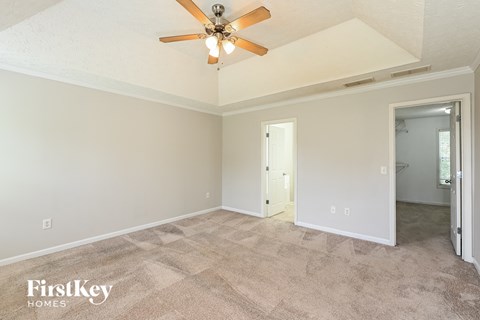 a living room with carpet and a ceiling fan