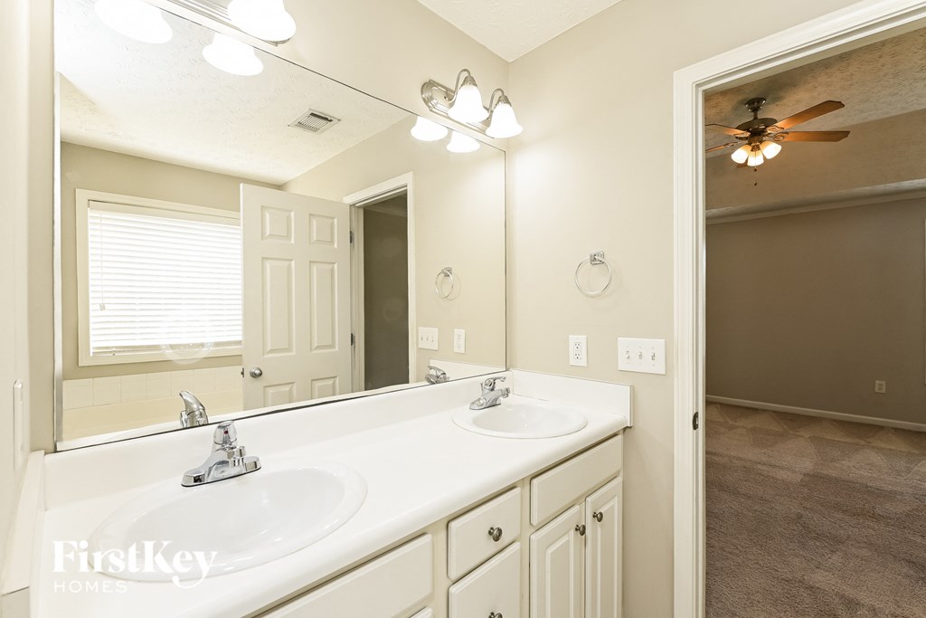 a bathroom with two sinks and a large mirror