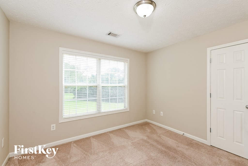 a bedroom with a large window and a white door