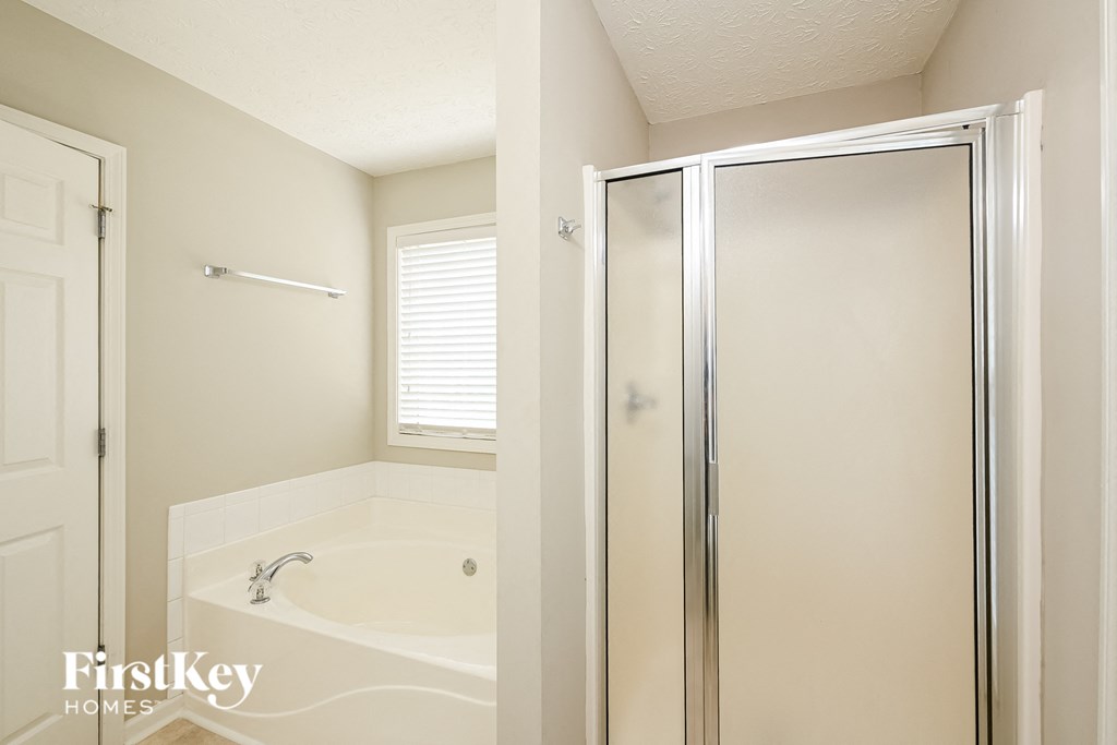 a small bathroom with a shower and a bath tub
