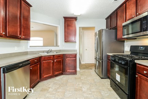 A kitchen with wooden cabinets and a tile floor.
