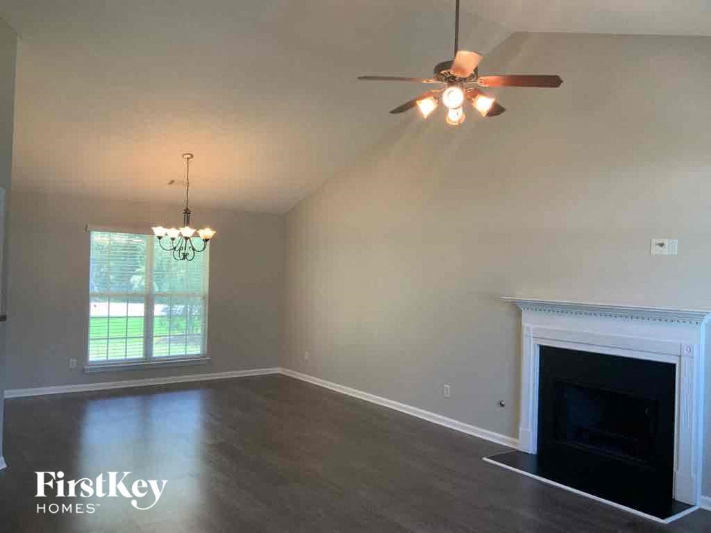 a living room with a fireplace and a ceiling fan