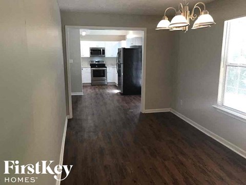 A kitchen with a refrigerator, oven, and microwave.