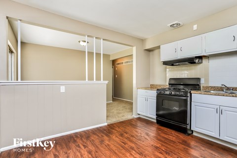 A kitchen with a black oven and white cabinets.