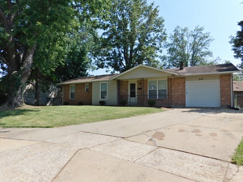 a small brick house with a white garage door