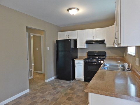 a kitchen with black appliances and white cabinets