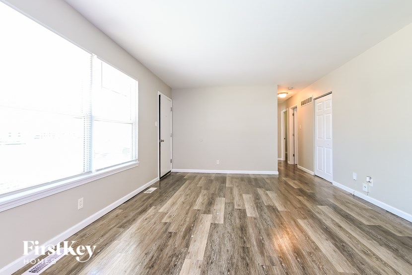 A room with wooden flooring and white walls.