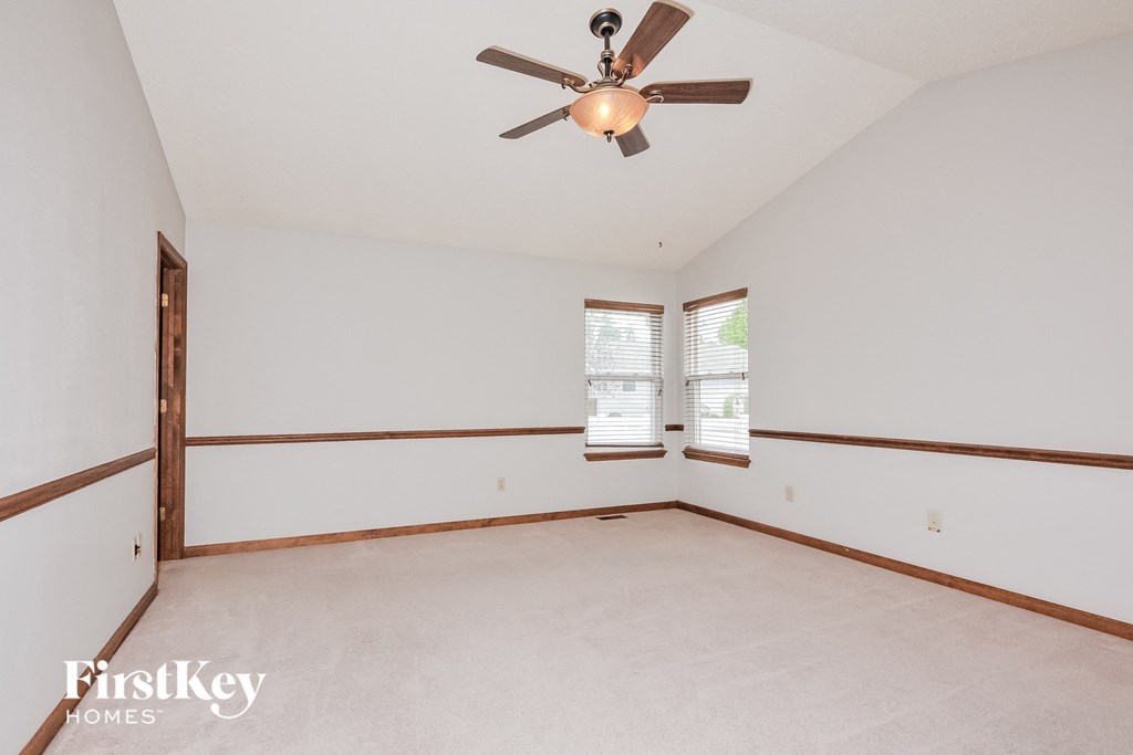 the living room of an empty house with a ceiling fan