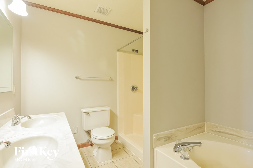 a bathroom with a toilet and a tub and a sink