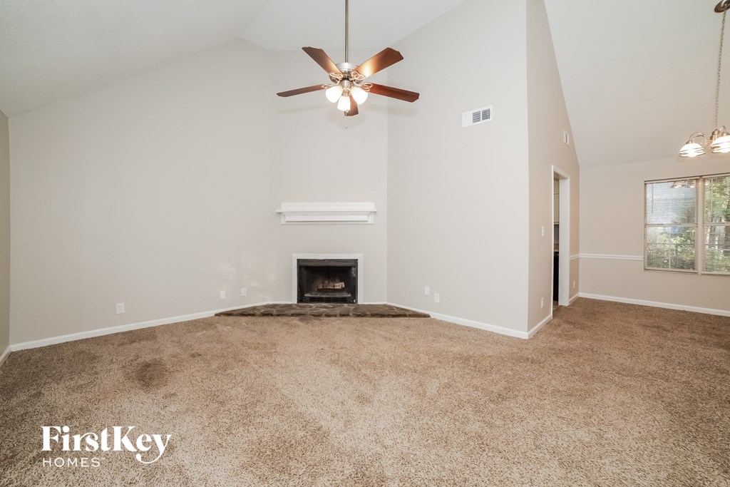 the living room has a fireplace and a ceiling fan