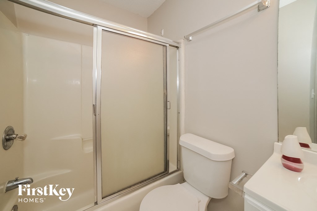 a white bathroom with a shower and a toilet