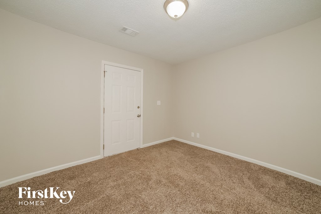 a bedroom with a carpeted floor and a white door