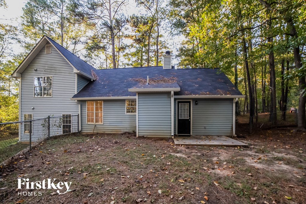 the front of the house with the woods behind it