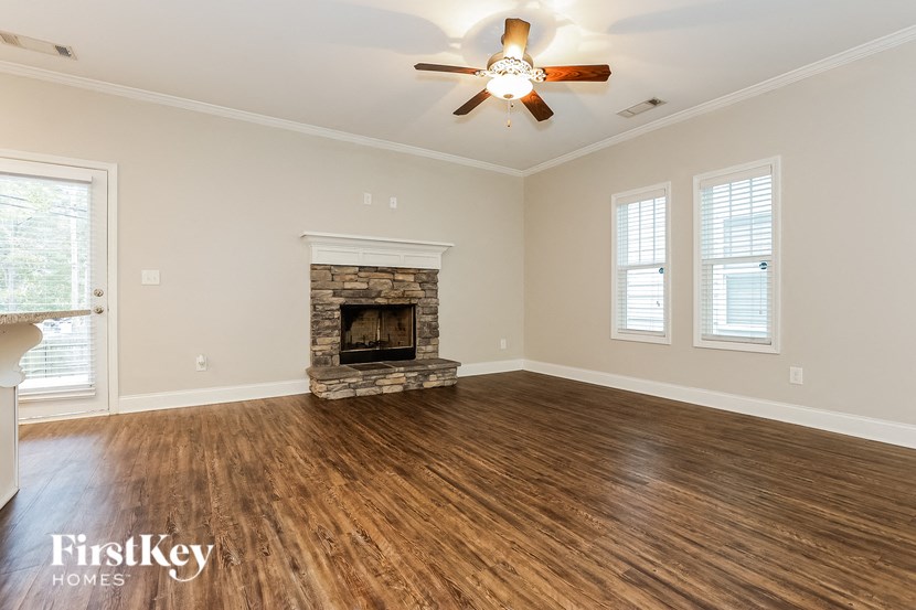 a living room with a fireplace and a ceiling fan