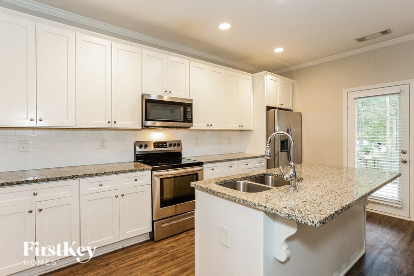 a kitchen with white cabinets and a granite counter top