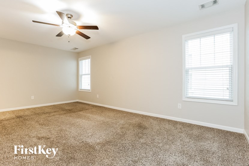 a room with carpet and a ceiling fan
