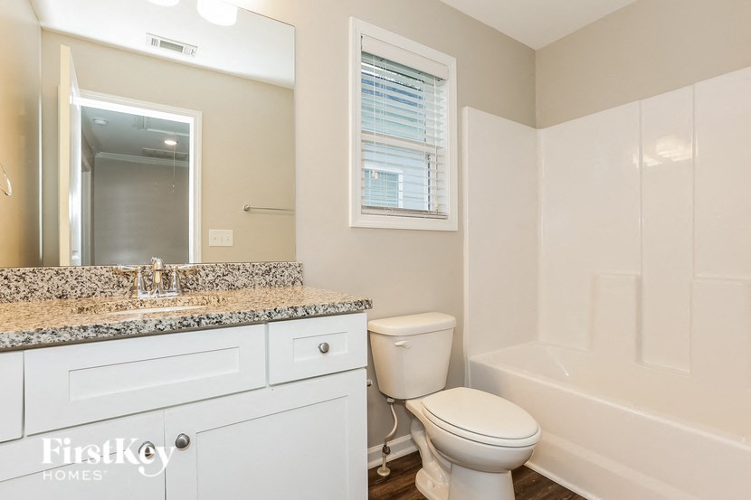 a bathroom with a toilet and a sink and a bath tub