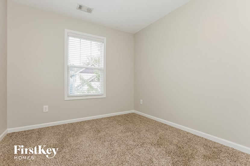 a bedroom with a carpeted floor and a window