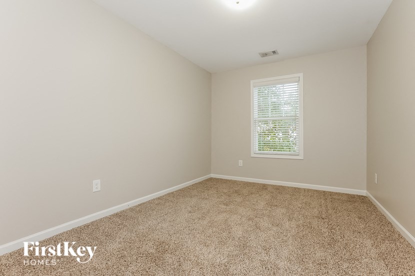 a bedroom with a carpeted floor and a window