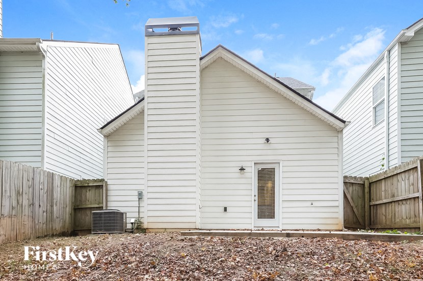 the outside of a white church with a wood fence