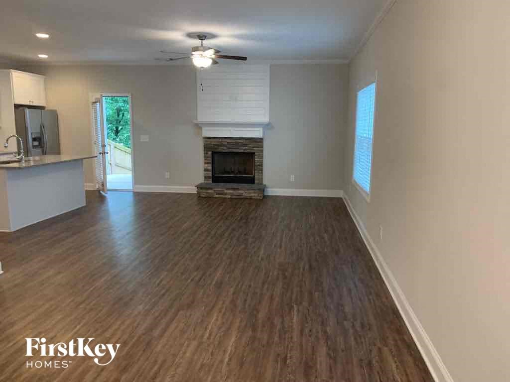 A spacious living room with wood flooring and a fireplace.