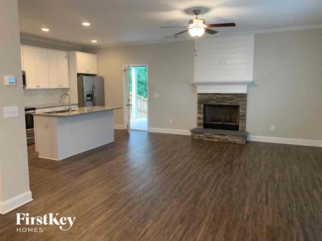 A spacious kitchen with wood flooring and a fireplace.
