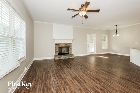 a living room with a fireplace and a ceiling fan