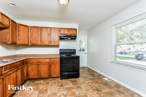 A kitchen with wooden cabinets and a black oven.