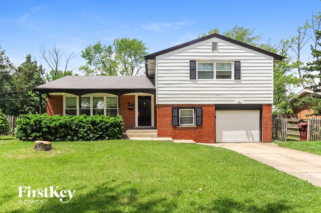 a brick and with a lawn and a white garage door