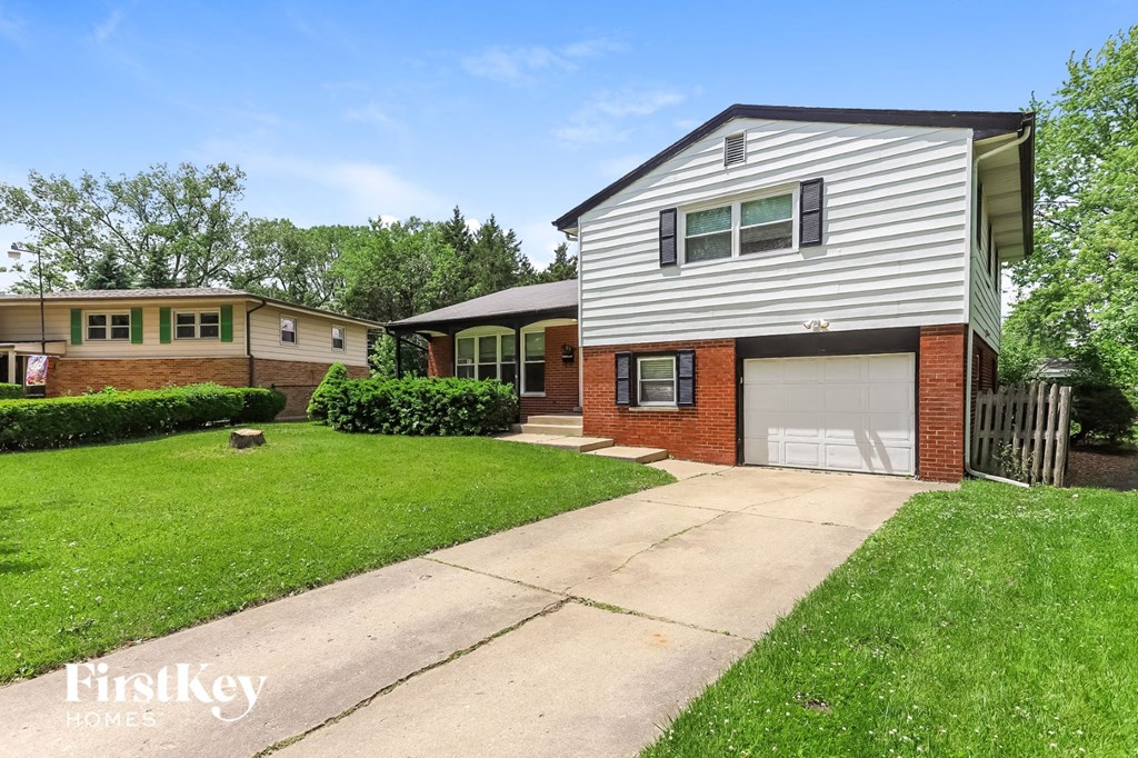 a white and brick house with a white garage door