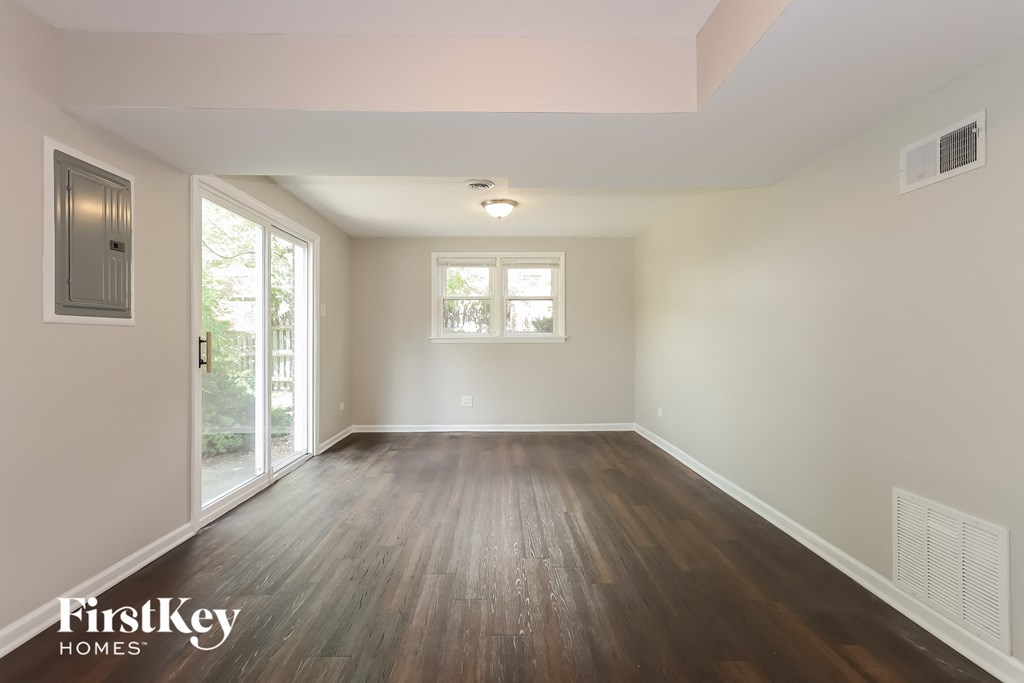 an empty living room with wood floors and a window