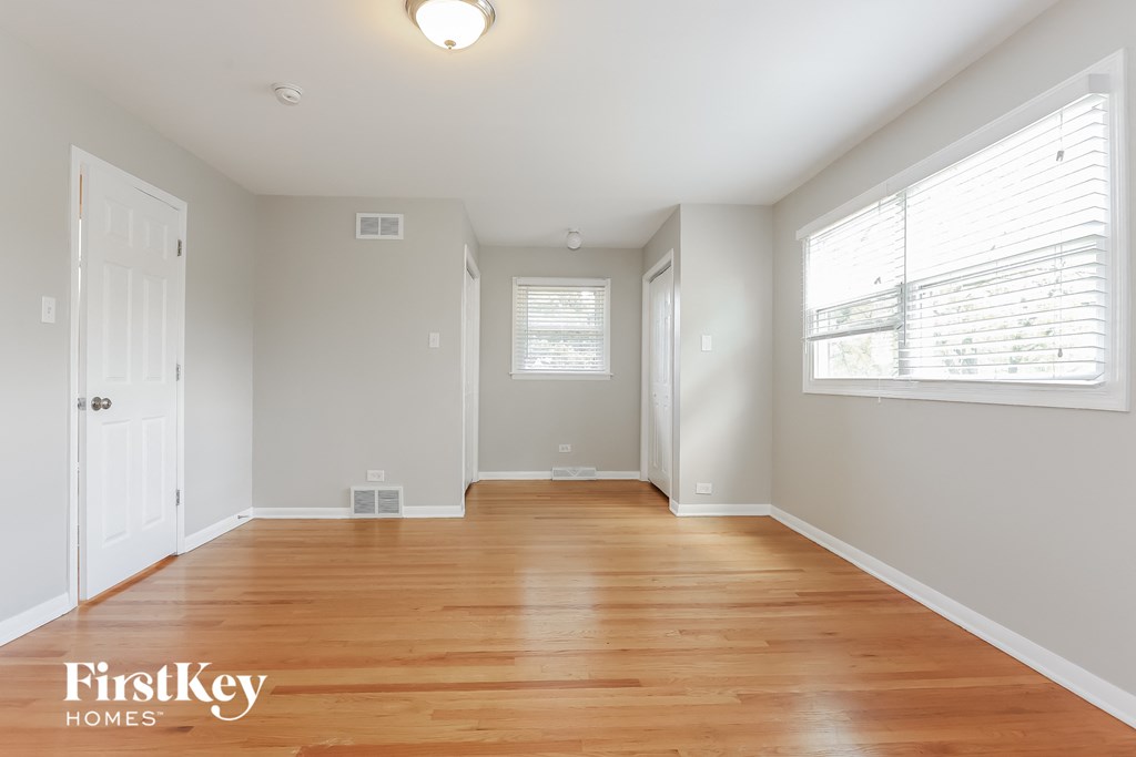 an empty room with wood floors and a window