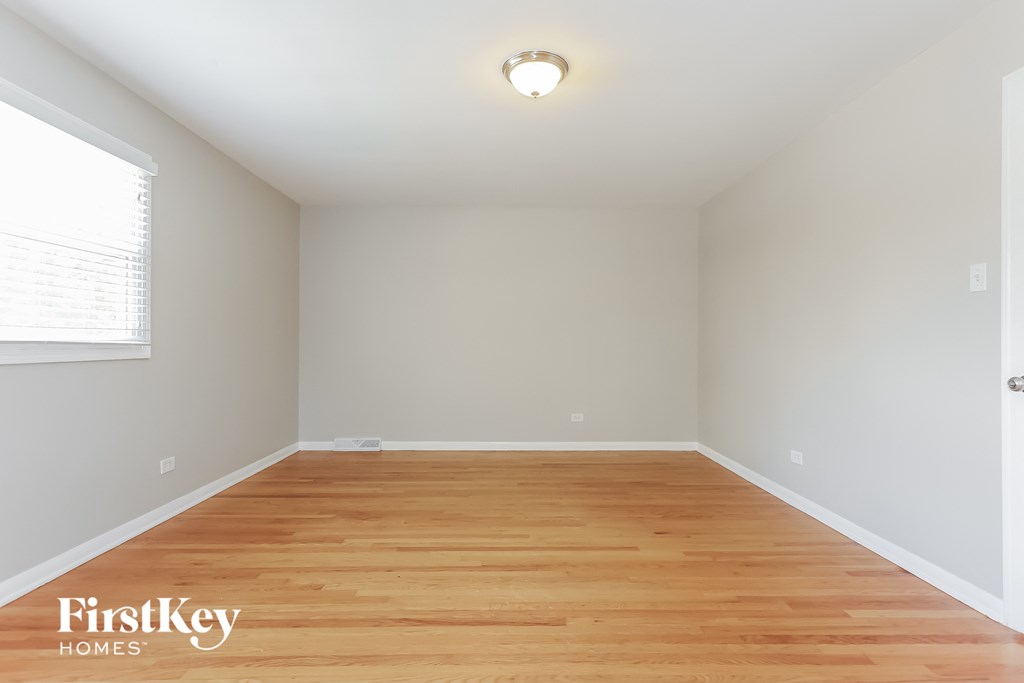 an empty room with wood floors and a window