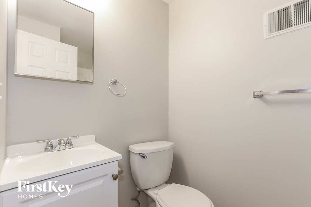 a bathroom with a toilet and a sink and a mirror
