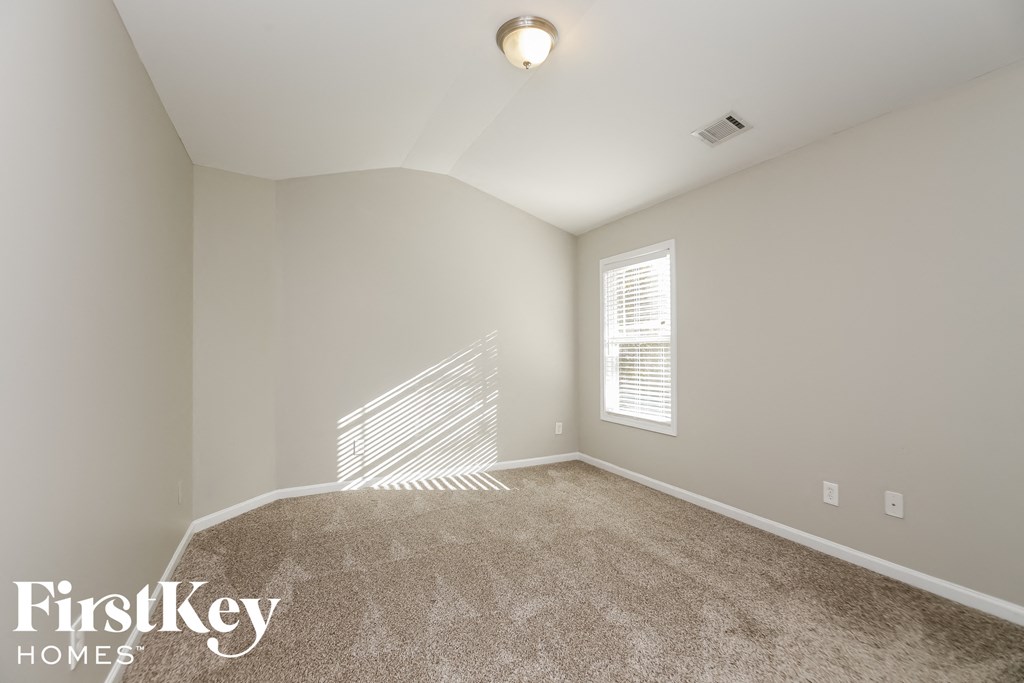 a spacious living room with carpet and a window