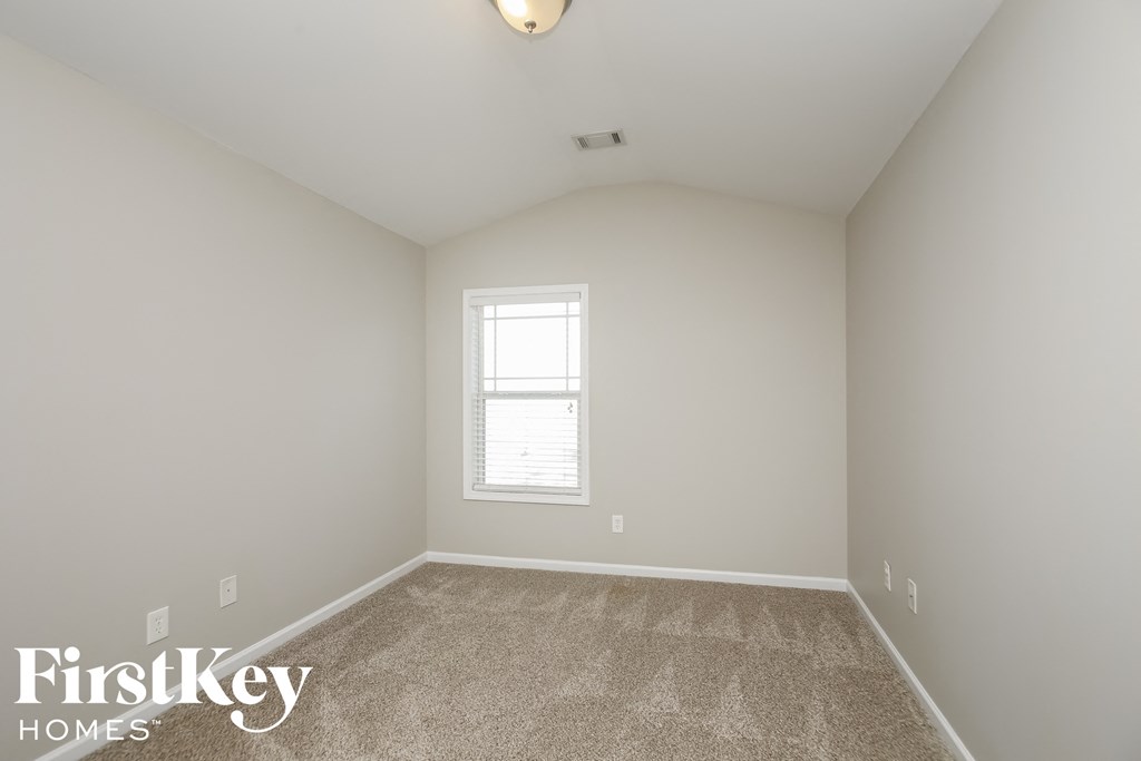 a bedroom with a carpeted floor and a window