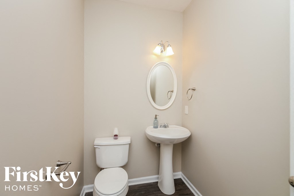 a bathroom with a toilet and a sink and a mirror