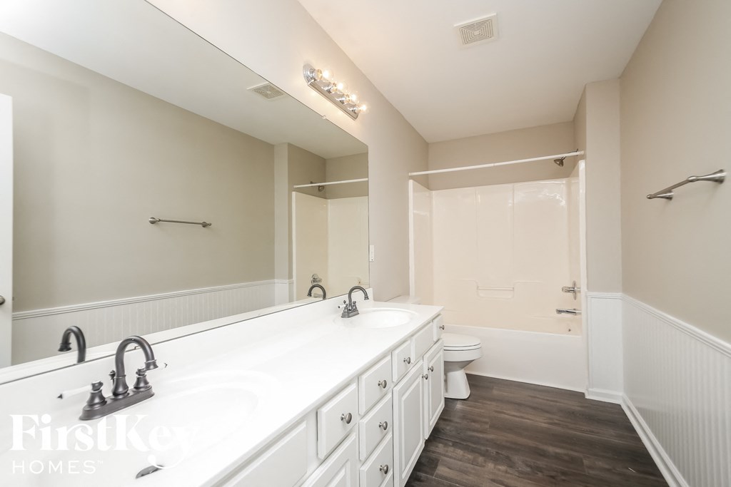 a bathroom with a white sink and a toilet and a shower