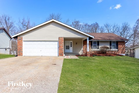 A house with a garage and a driveway in front.