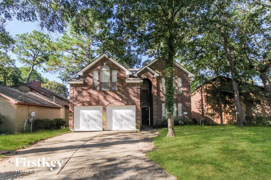 a brick house with two white garage doors